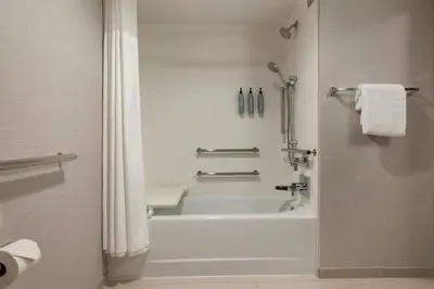 a bathroom with a white tub and a shower at Courtyard by Marriott Sacramento Midtown in Sacramento