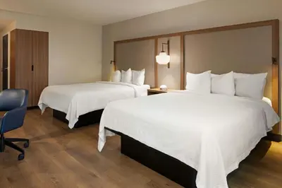 a hotel room with two beds and a chair at Fairfield Inn Sacramento Cal Expo in Sacramento