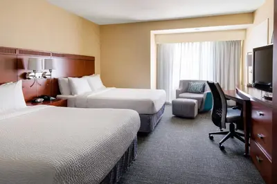 a hotel room with two beds and a desk and a chair at Courtyard by Marriott Sacramento Cal Expo in Sacramento
