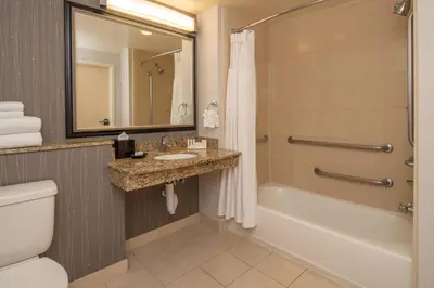a bathroom with a tub and a sink and a toilet at Courtyard by Marriott Sacramento Cal Expo in Sacramento