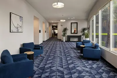 a waiting room with blue chairs and a fireplace at Courtyard by Marriott Sacramento Cal Expo in Sacramento
