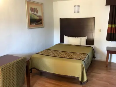 a hotel room with a bed and a table at Americas Best Value Inn Visalia in Visalia