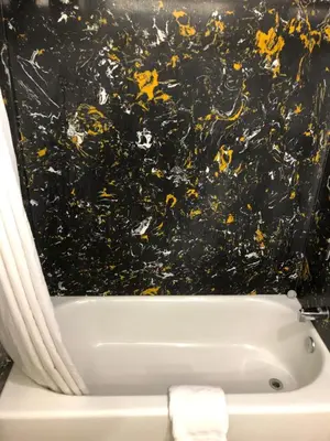 a bathroom with a bath tub with a black wall at Americas Best Value Inn Visalia in Visalia