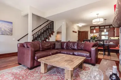 a living room with a brown leather couch and a table at Juniper Crest 3 in Old Mammoth
