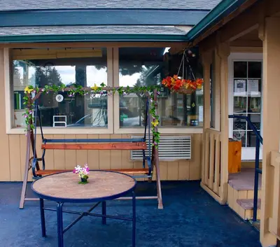 a porch with a table and a chair and flowers at The Trailhead in South Lake Tahoe