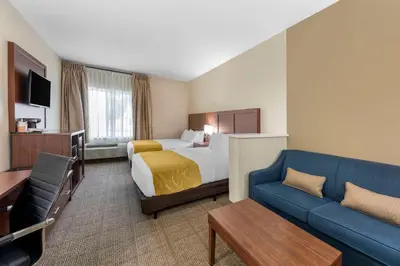 a hotel room with a bed and a couch at Comfort Suites Tulare Sequoia Gateway in Tulare