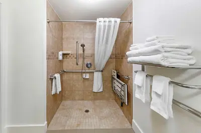 a bathroom with a shower with white towels at Comfort Suites Tulare Sequoia Gateway in Tulare