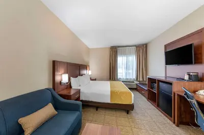 a hotel room with a bed and a couch at Comfort Suites Tulare Sequoia Gateway in Tulare