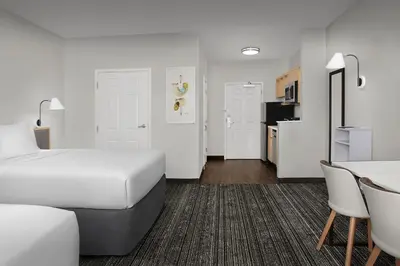 a hotel room with a bed and a table and chairs at TownePlace Suites Sacramento Cal Expo in Sacramento