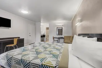 a bedroom with a bed and a living room at Motel 6-Lodi, CA in Lodi