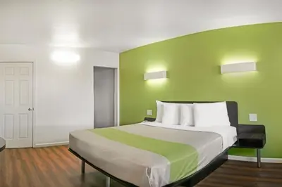 a bedroom with a large bed with a green wall at Motel 6-Visalia, CA in Visalia