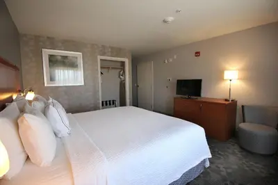 a hotel room with a bed and a television at Courtyard by Marriott Merced in Merced
