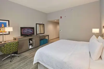 a hotel room with a bed and a desk and a television at Hampton Inn & Suites Sacramento at CSUS in Sacramento