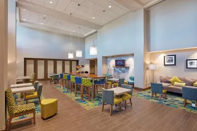 a waiting room with tables and chairs and a couch at Hampton Inn & Suites Sacramento at CSUS in Sacramento