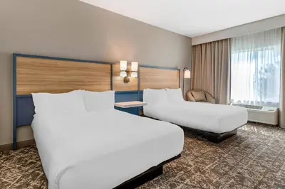 a hotel room with two beds and a chair at Country Inn & Suites by Radisson, Modesto-Salida in Modesto