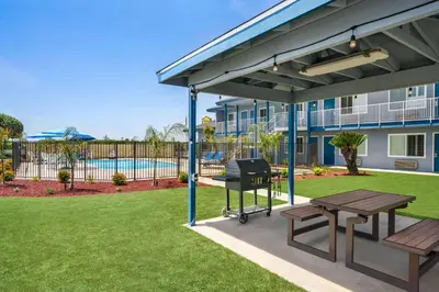 a covered patio with a picnic table and a grill at Super 8 by Wyndham Lindsay Olive Tree in Lindsay
