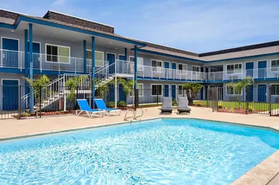 a swimming pool in front of a apartment building at Super 8 by Wyndham Lindsay Olive Tree in Lindsay
