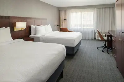 a hotel room with two beds and a desk at Courtyard Carson City in Carson City