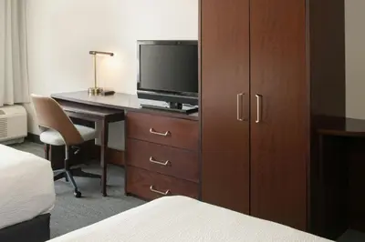 a hotel room with a desk with a tv and a cabinet at Courtyard Carson City in Carson City