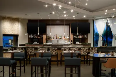a bar in a restaurant with tables and chairs at Sacramento Marriott Rancho Cordova in Rancho Cordova