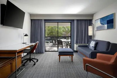 a hotel room with a desk and a couch and a desk at Courtyard by Marriott Stockton in Stockton
