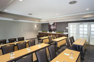 a restaurant with wooden tables and chairs and a bar at Courtyard by Marriott Stockton in Stockton