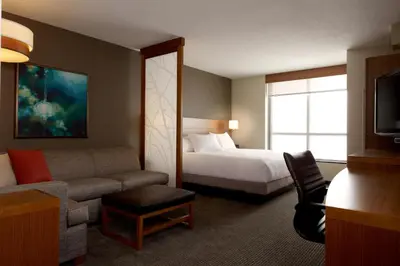 a hotel room with a bed and a couch at Hyatt Place Delano in Delano