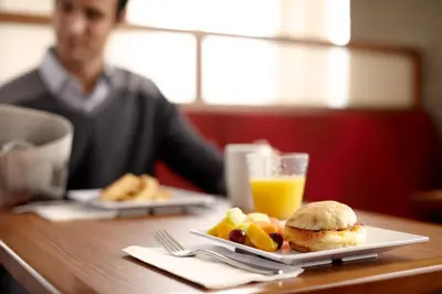 a table with a plate of food and a glass of orange juice at Hyatt Place Delano in Delano