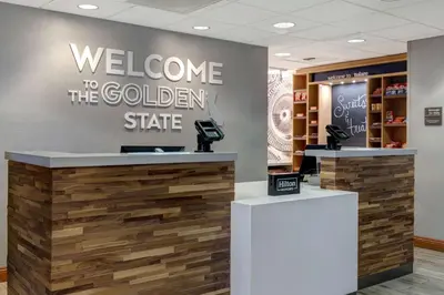 a welcome to the golden state sign in a store lobby at Hampton Inn & Suites Tulare in Tulare