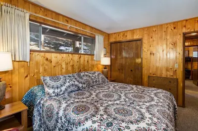 a bedroom with a bed and wooden walls at 24B Birds Eye View in Wawona
