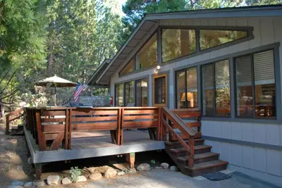 a house with a large deck and windows at 23A Big Cedar in Wawona