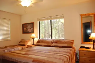 a bedroom with two beds and a large window at 23A Big Cedar in Wawona