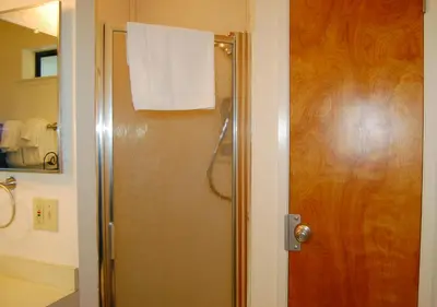 a bathroom with a shower with a white towel on the door at 23A Big Cedar in Wawona