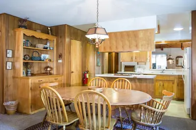 a kitchen with a wooden table and chairs at 2B Quail Meadow in Wawona
