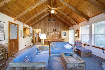 a living room with blue furniture and wooden ceilings at 2B Quail Meadow in Wawona