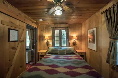 a bedroom with a bed with a ceiling fan at 14 Chipmunk Hollow in Wawona