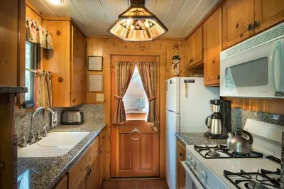a kitchen with a white refrigerator and a sink at 14 Chipmunk Hollow in Wawona