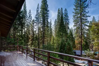 a deck with a view of the woods at 11B Sequoia House in Wawona