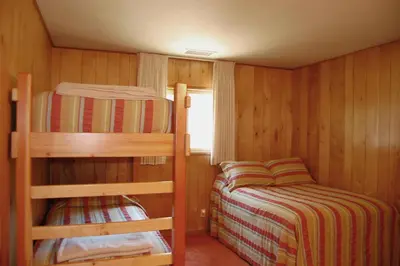 a small room with two bunk beds and a window at 39 River Song in North Wawona