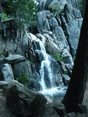 a waterfall on the side of a rocky mountain at 39 River Song in North Wawona