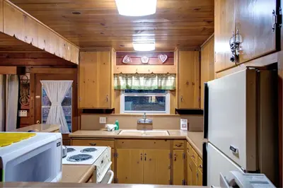 a kitchen with wooden cabinets and a white refrigerator at 22B Bradleys Cabin in Wawona