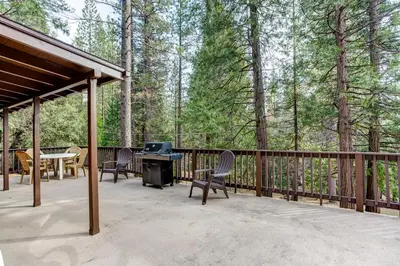 a patio with a table and chairs and a grill at 22B Bradleys Cabin in Wawona