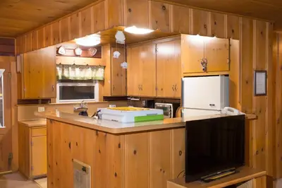 a kitchen with wooden cabinets and a counter top at 22B Bradleys Cabin in Wawona
