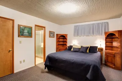 a bedroom with a bed with a blue comforter at 22B Bradleys Cabin in Wawona