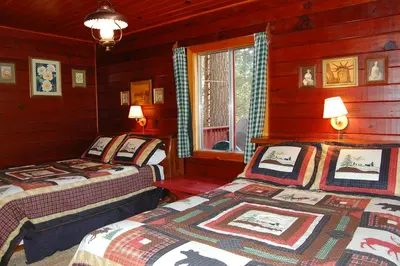 a bedroom with two beds in a log cabin at 3N Lockwood Lodge in Wawona