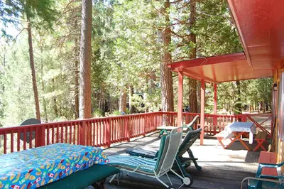 a porch with chairs and a table on a deck at 3N Lockwood Lodge in Wawona