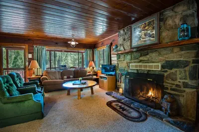 a large living room with a stone fireplace at 3N Lockwood Lodge in Wawona