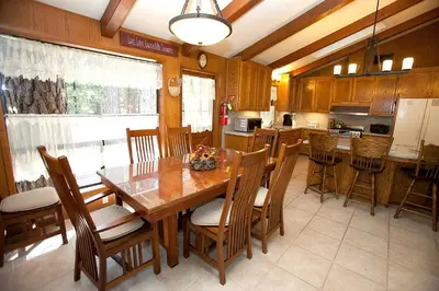 a kitchen with a wooden dining table and chairs at 48R The Tree House II in Wawona