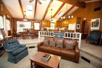 a living room with a couch and chairs and a kitchen at 48R The Tree House II in Wawona