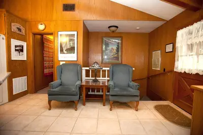 two chairs and a table in a room with wooden walls at 48R The Tree House II in Wawona
